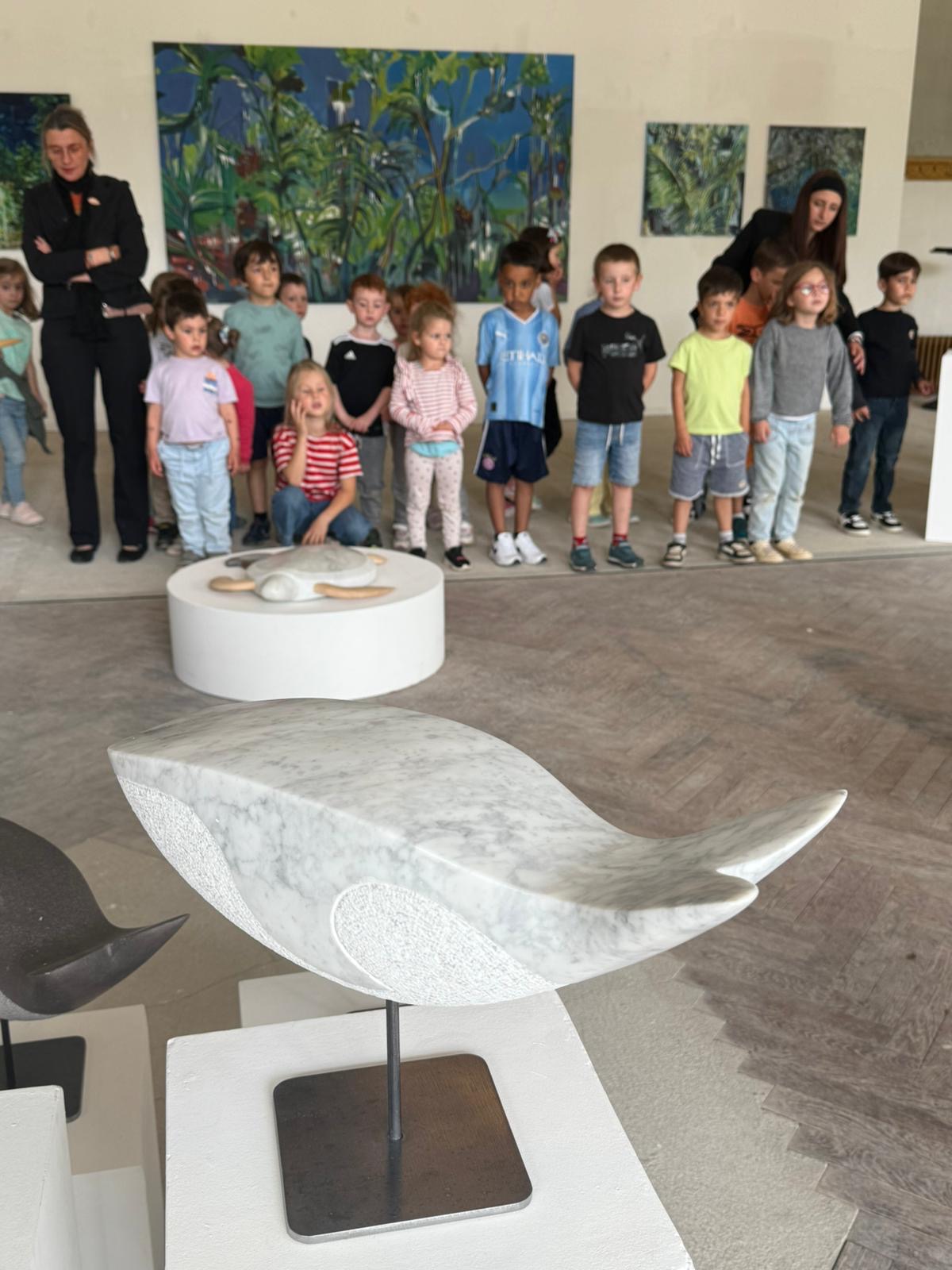 Des enfants en visite devant les sculptures de l'exposition