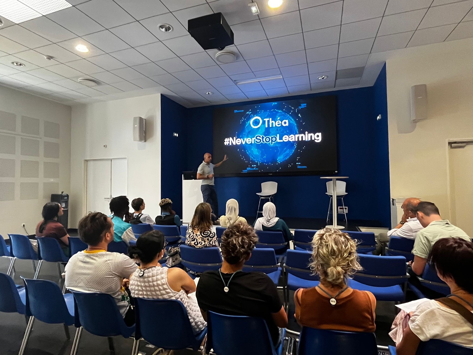 Présentation devant un groupe de jeunes dans l'auditorium du laboratoire Théa